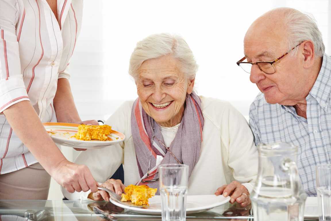 Gemeinschaftsverpflegung, Pflegeeinrichung Konzepte für die Seniorenverpflegung Ein Mann und eine Frau essen zusammen an einem Tisch.